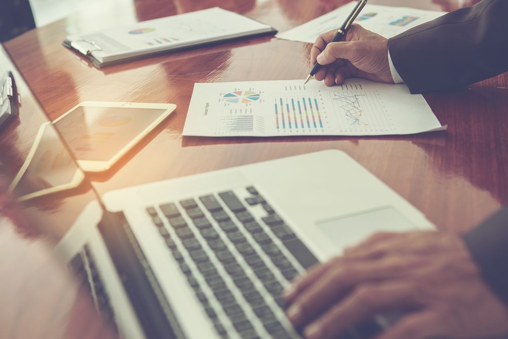 Person in Suit Analyzing Data With Pen, Laptop — Midcoast Financial Planning Group in Taree, NSW