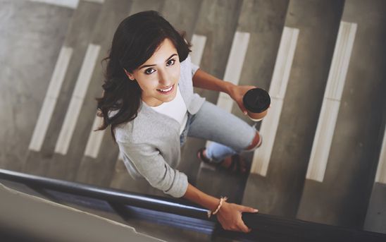 Woman with Coffee Cup on Stairs — Midcoast Financial Planning Group in Tuncurry, NSW
