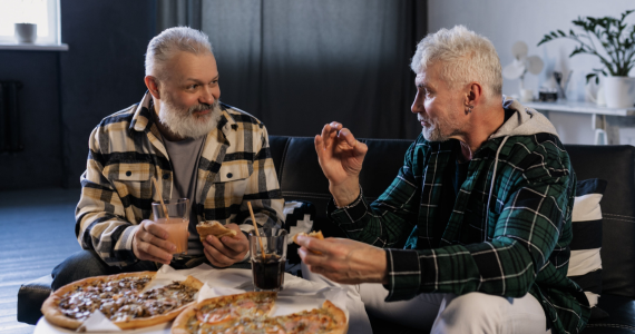 Two Men Eating Pizza, Talking — Midcoast Financial Planning Group in Tuncurry, NSW
