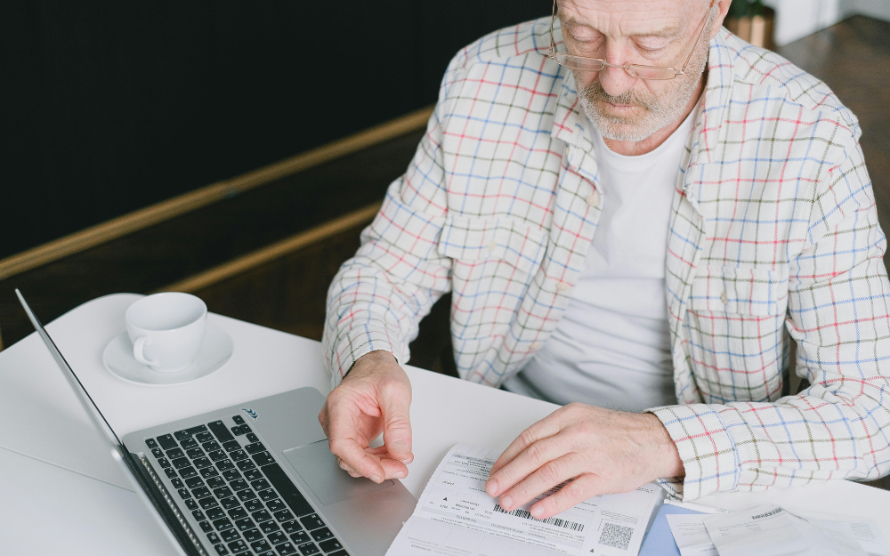 Man Looking at Papers Credit repair - Midcoast Financial Planning Group