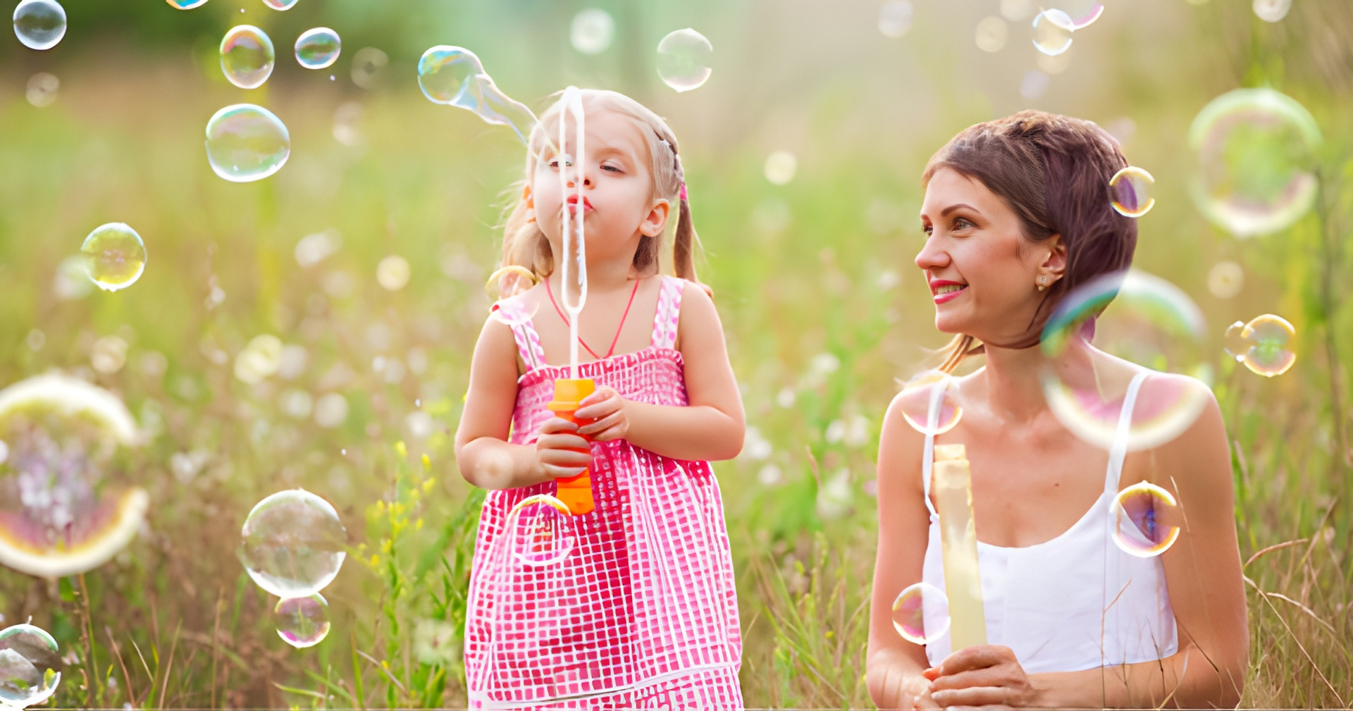 Girl Blowing Bubbles; Woman Watches. Both Are in a Grassy Field — Midcoast Financial Planning Group in Tuncurry, NSW