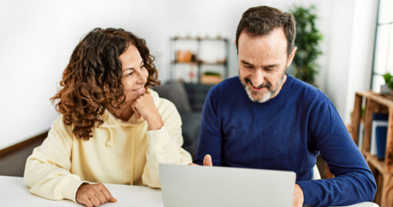 Couple Looking at a Laptop — Midcoast Financial Planning Group in Tuncurry, NSW