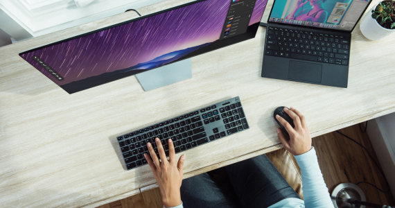 Person Typing on Keyboard at Desk With Monitor and Laptop — Midcoast Financial Planning Group in Tuncurry, NSW