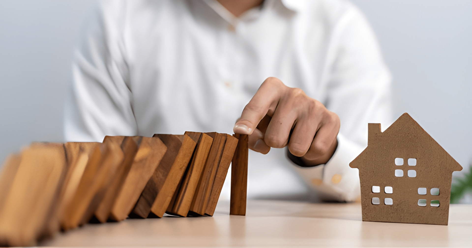 Hand Stopping Dominoes From Falling — Midcoast Financial Planning Group in Tuncurry, NSW