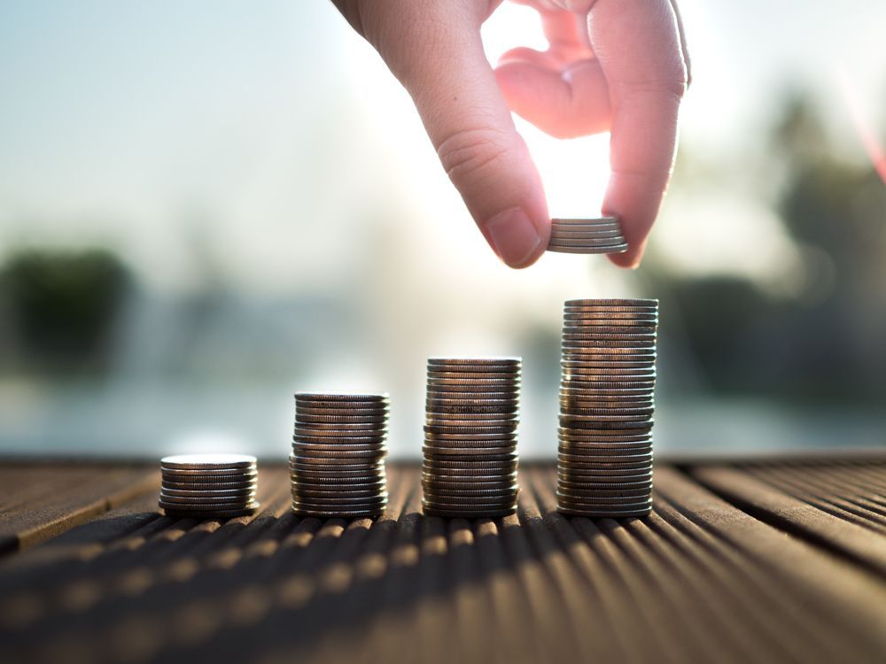 Hand Adding Coins to a Growing Stack — Midcoast Financial Planning Group in Tuncurry, NSW