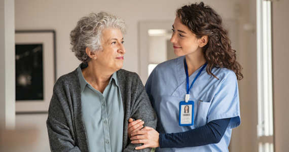Woman in Blue Scrubs Assists Older Woman — Midcoast Financial Planning Group in Tuncurry, NSW