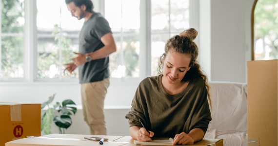 Woman Seated, Writing on A Box — Midcoast Financial Planning Group in Tuncurry, NSW