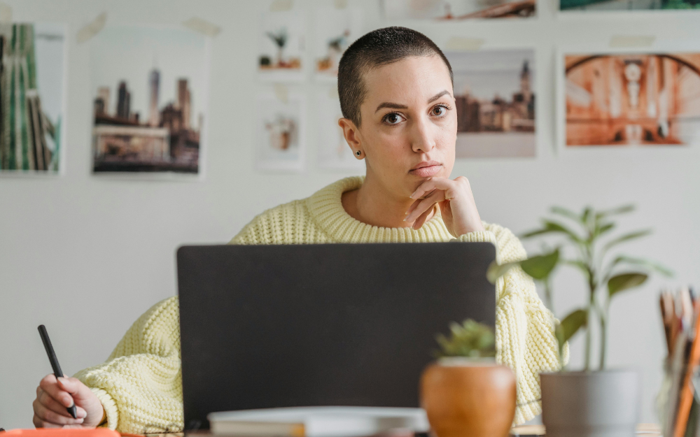 Woman with Shaved Head Working on Laptop — Midcoast Financial Planning Group in Tuncurry, NSW