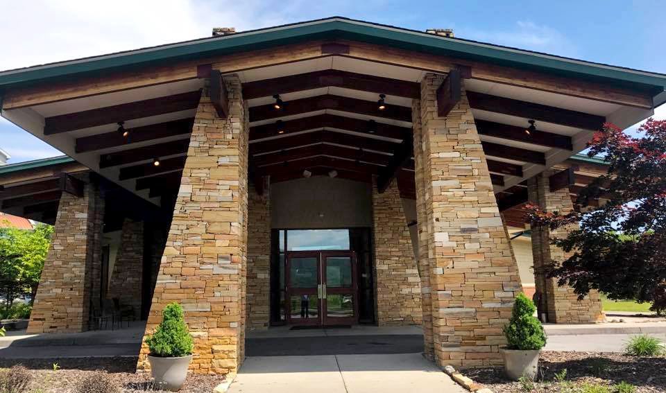 The entrance to a large stone building with a green roof.