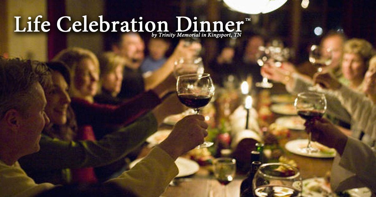 A group of people toasting with wine glasses at a life celebration dinner