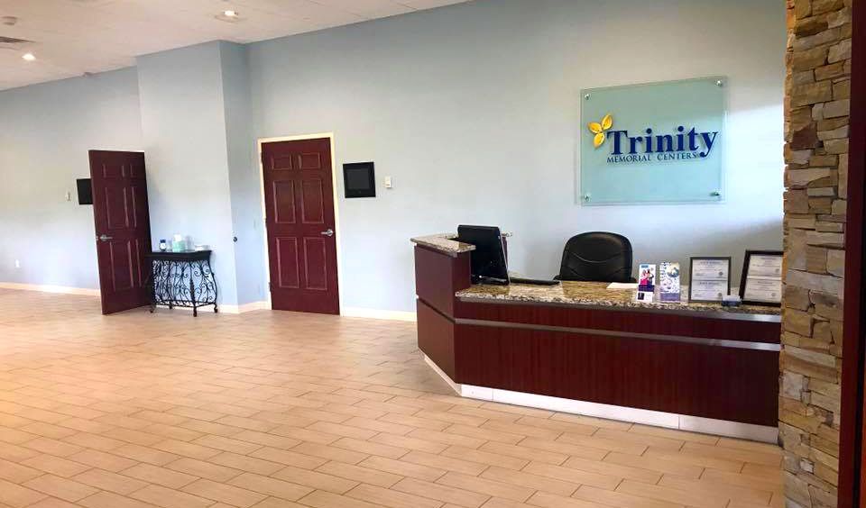 A large room with a reception desk and a sign that says trinity