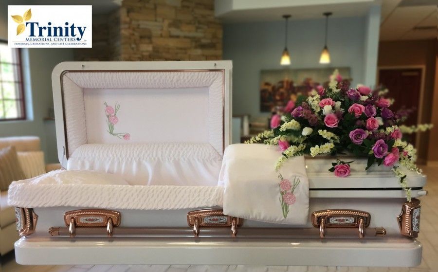 A white coffin with pink and purple flowers on it