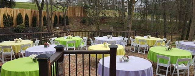 A deck with tables and chairs set up for a party.