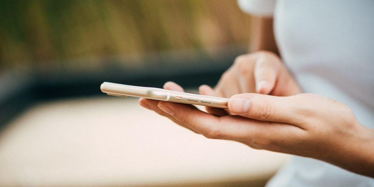 A woman is holding a cell phone in her hand.