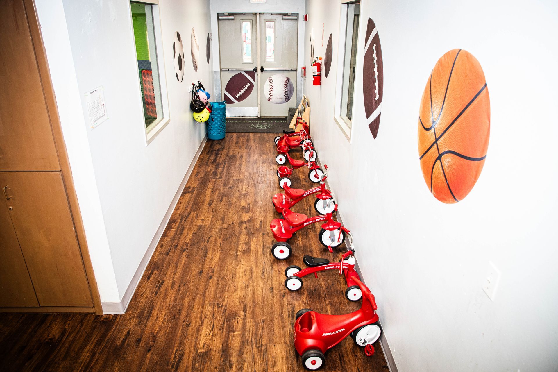 a hallway with a bunch of red bikes and a basketball on the wall .