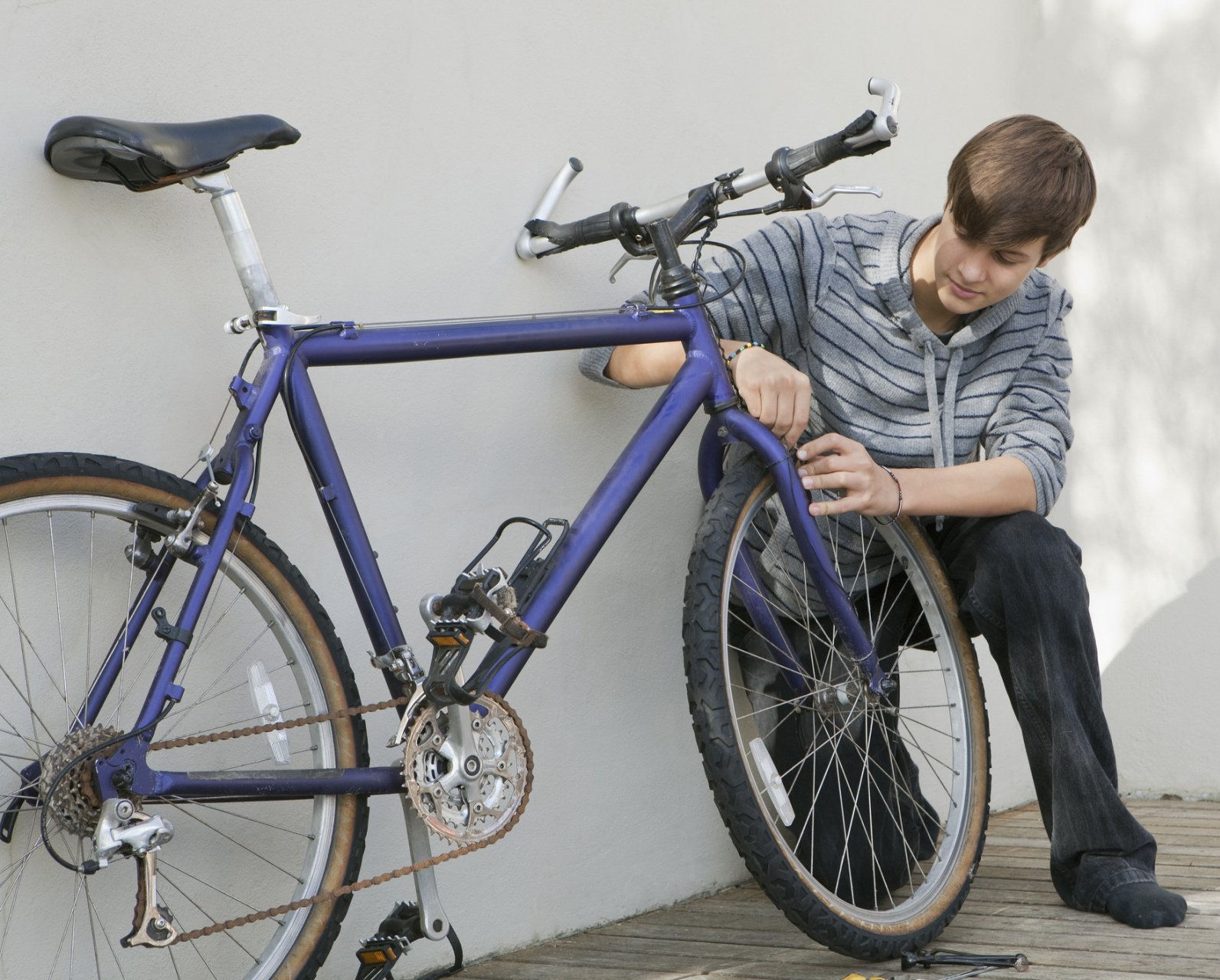 Bike Repair Services — Teenage Boy Repairing Bicycle in Gilbert, AZ