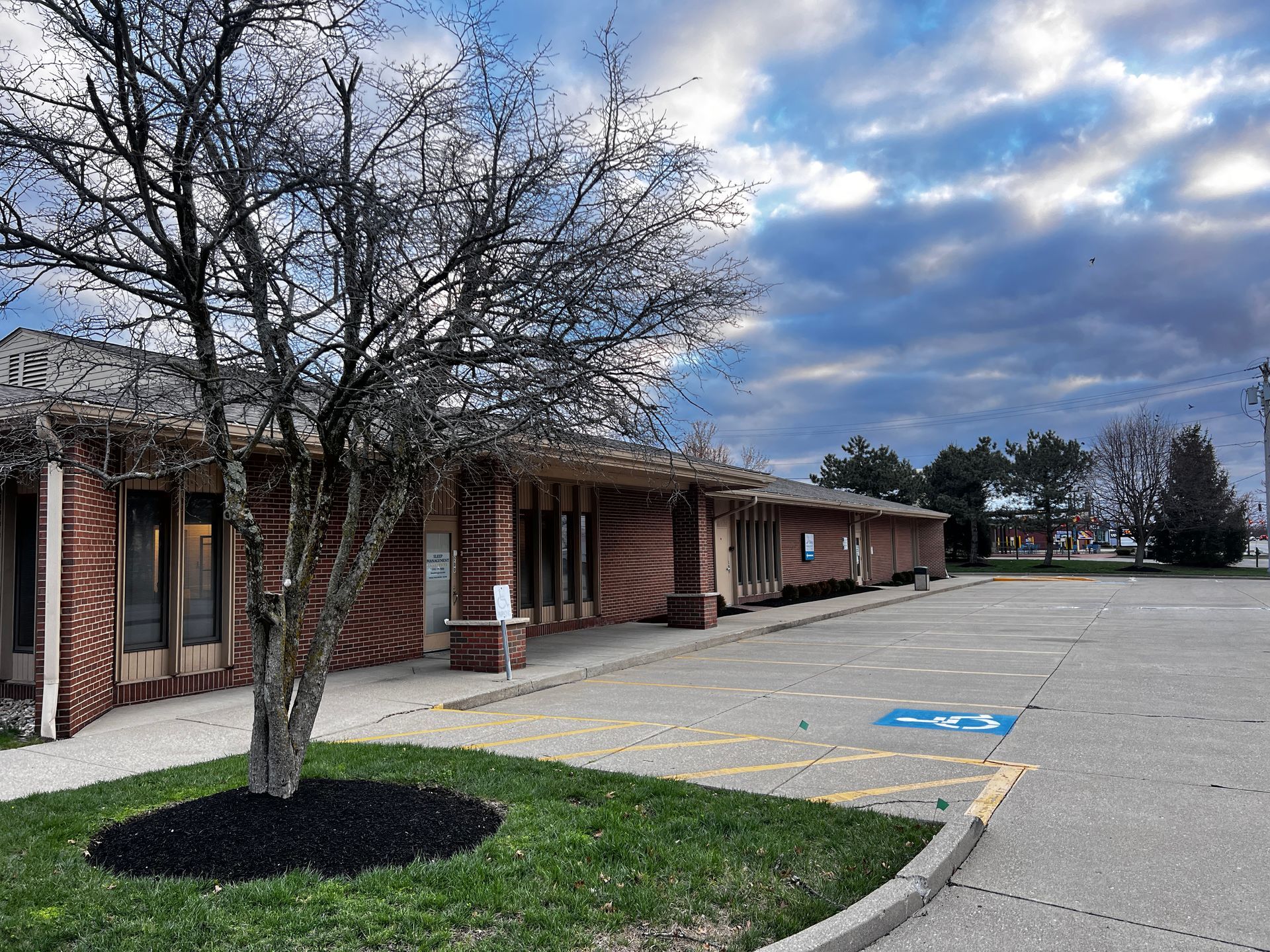 A brick building with a handicapped parking spot in front of it | Intrepid Research