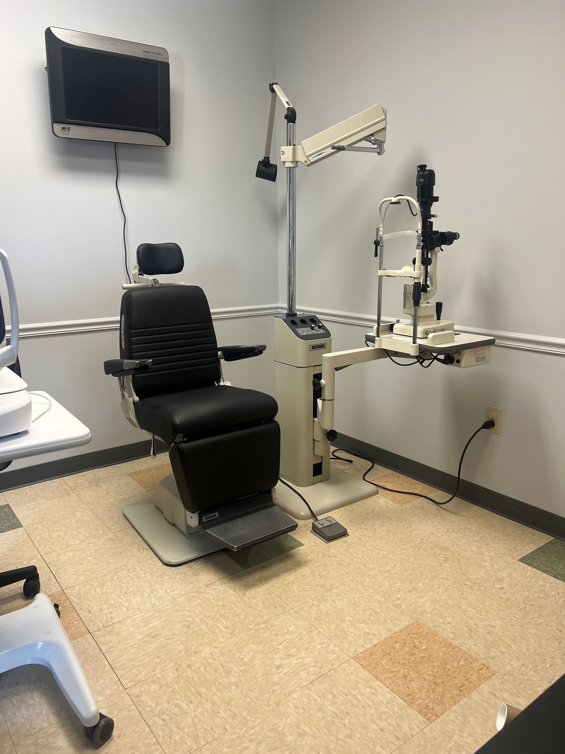 An ophthalmologist 's office with a chair and a microscope | Intrepid Research