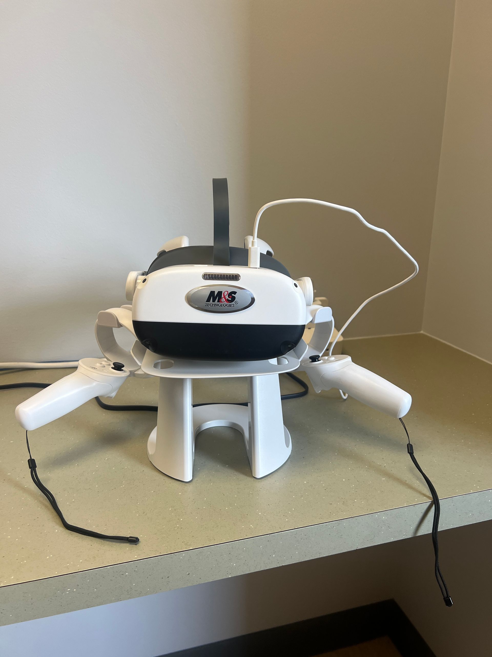 A virtual reality headset is sitting on a table with two controllers attached to it | Intrepid Research