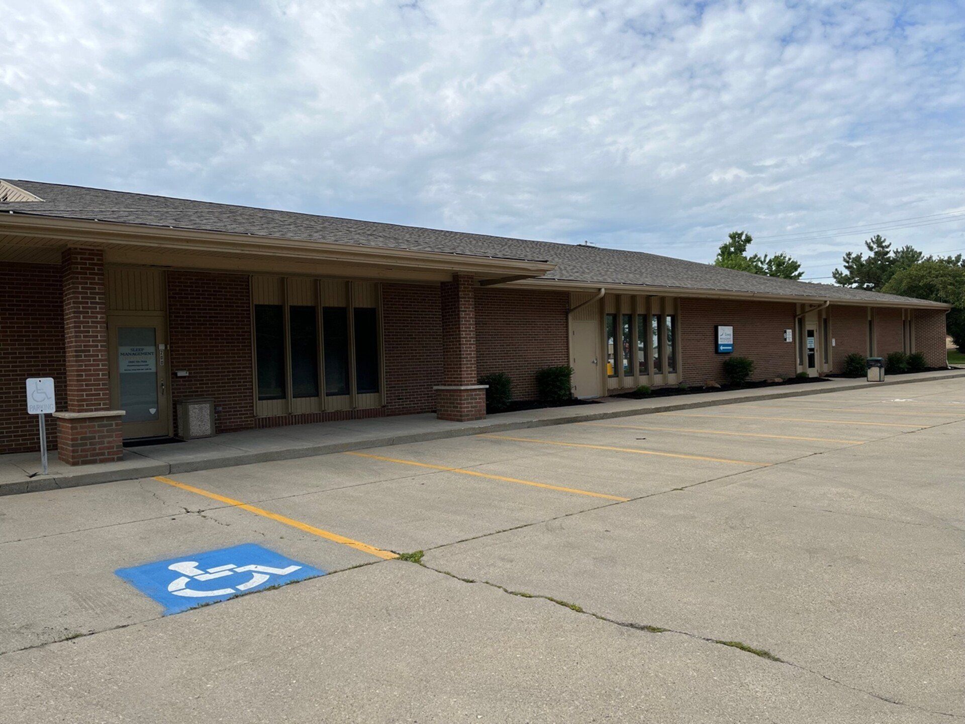 A large brick building with a handicapped parking spot in front of it | Intrepid Research