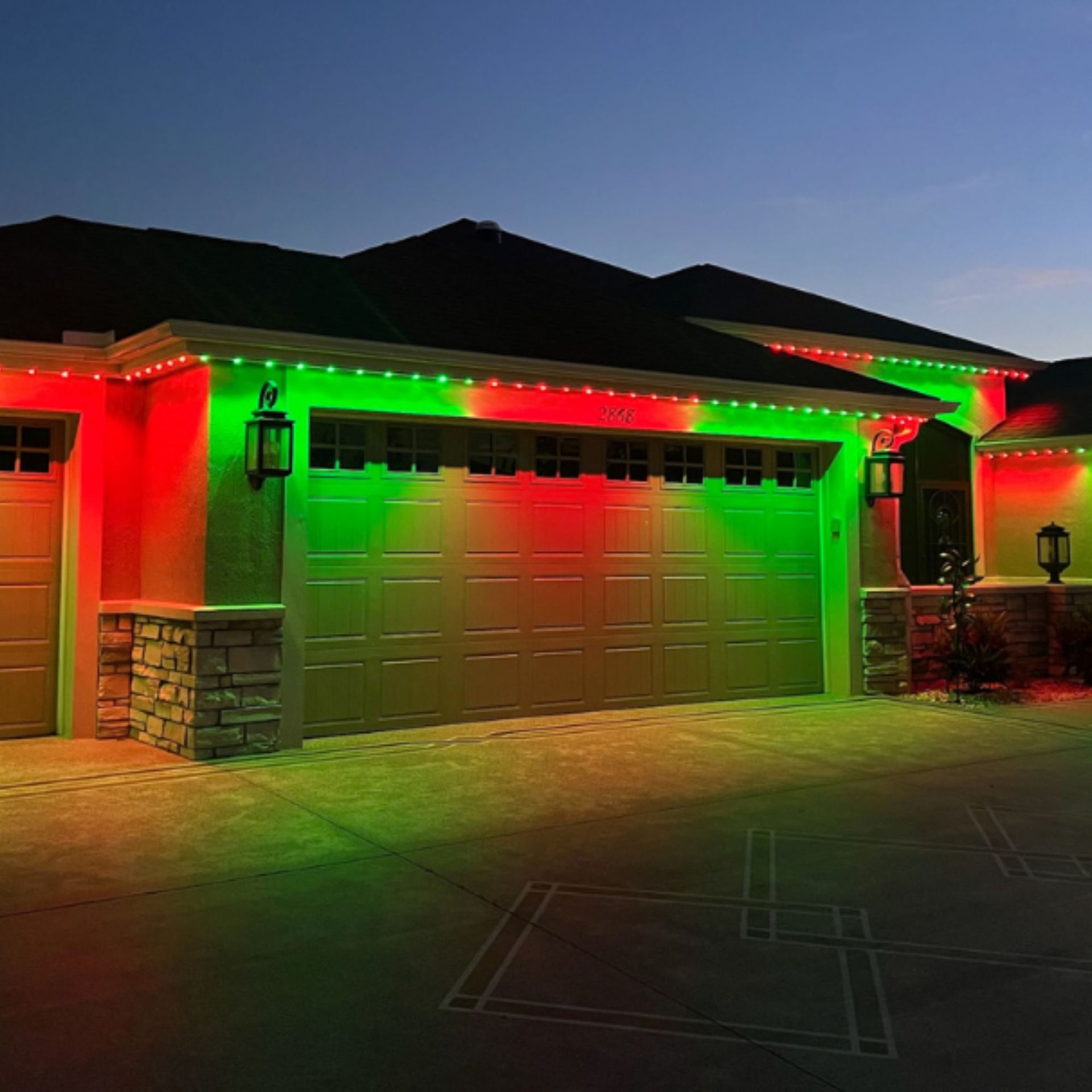 Silvers, Inc. - House with red and green Christmas lights illuminating the garage and roof.