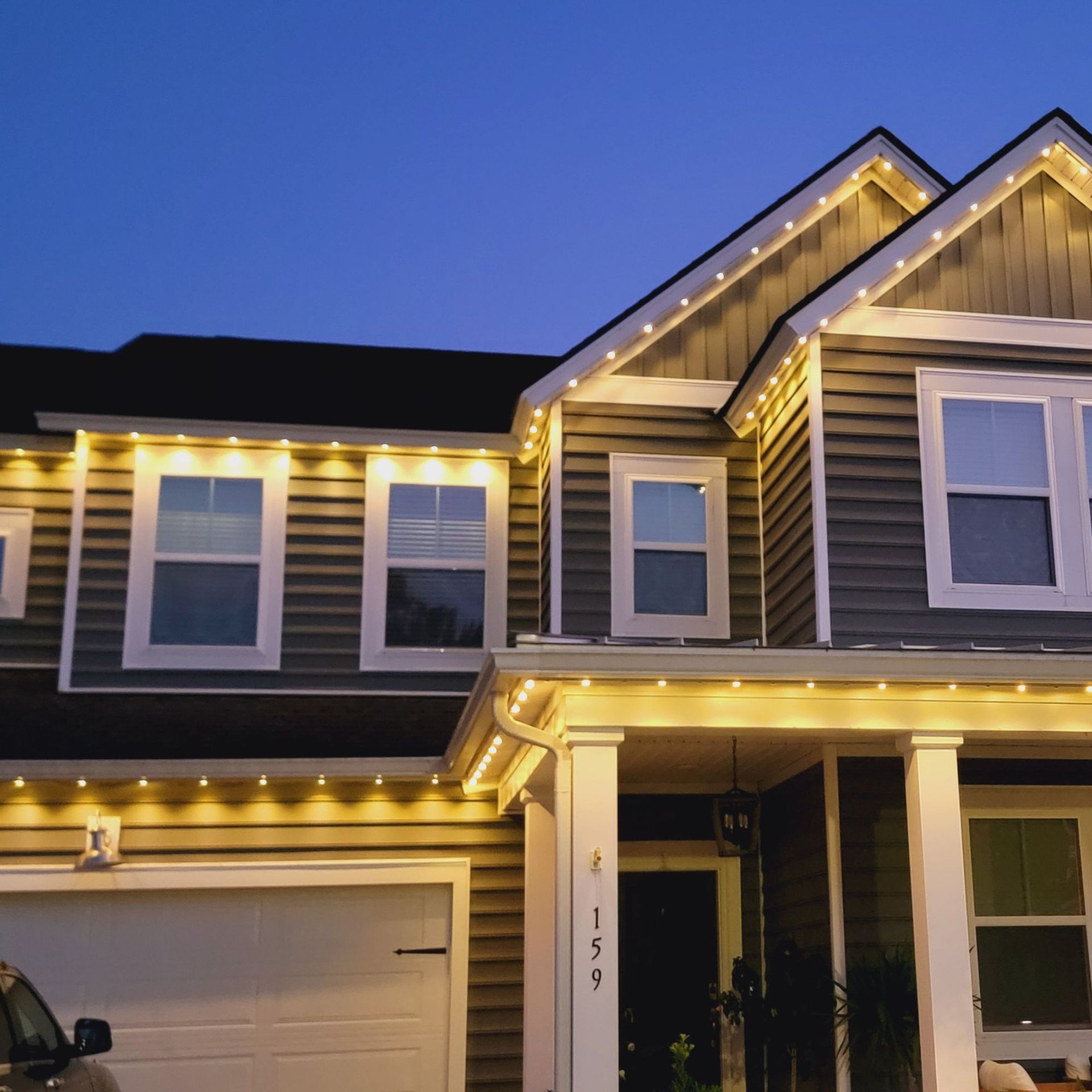 Silvers, Inc. - House exterior at dusk with warm white lights outlining roof and windows.
