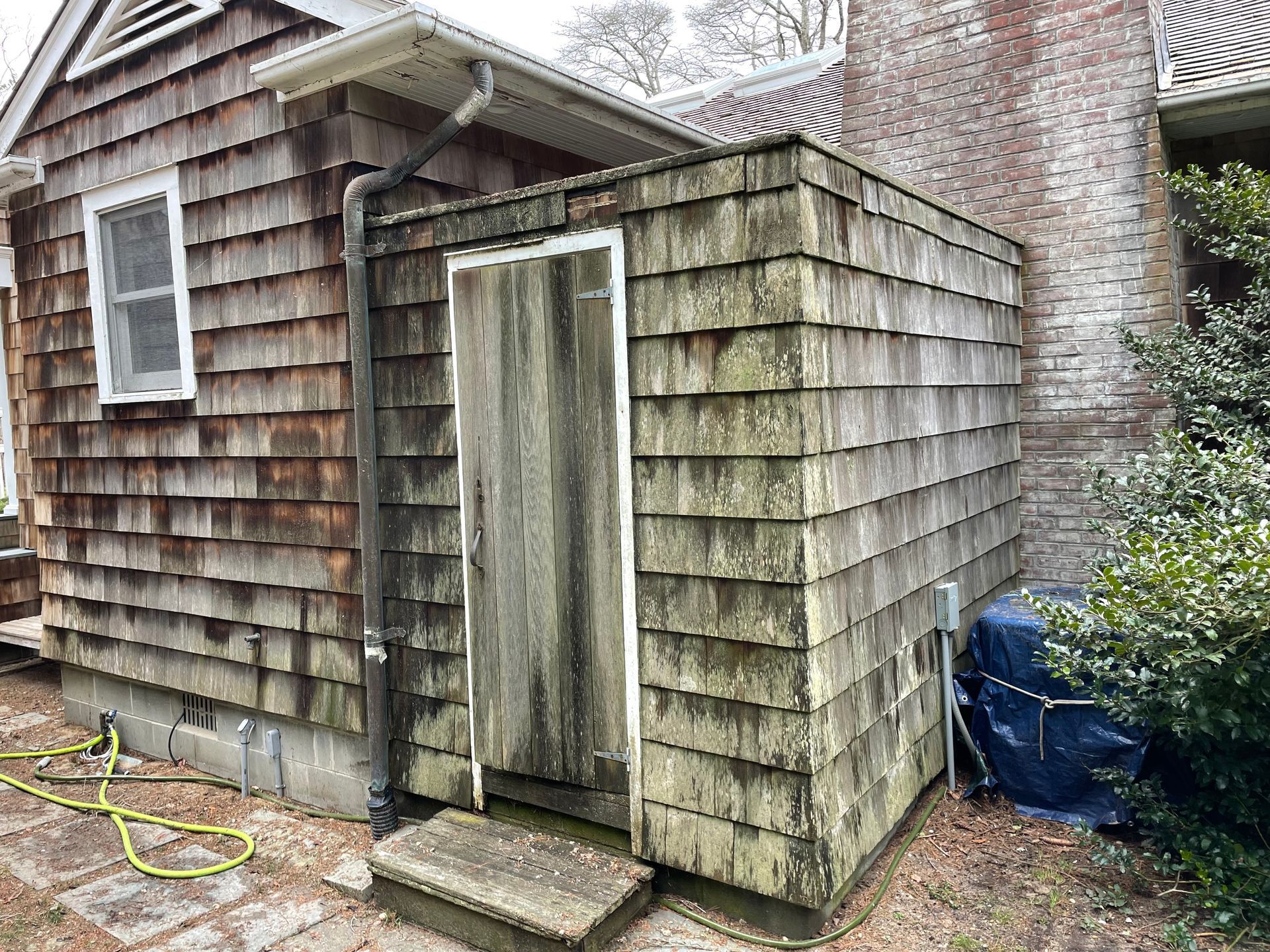 A small wooden shed before pressure washing