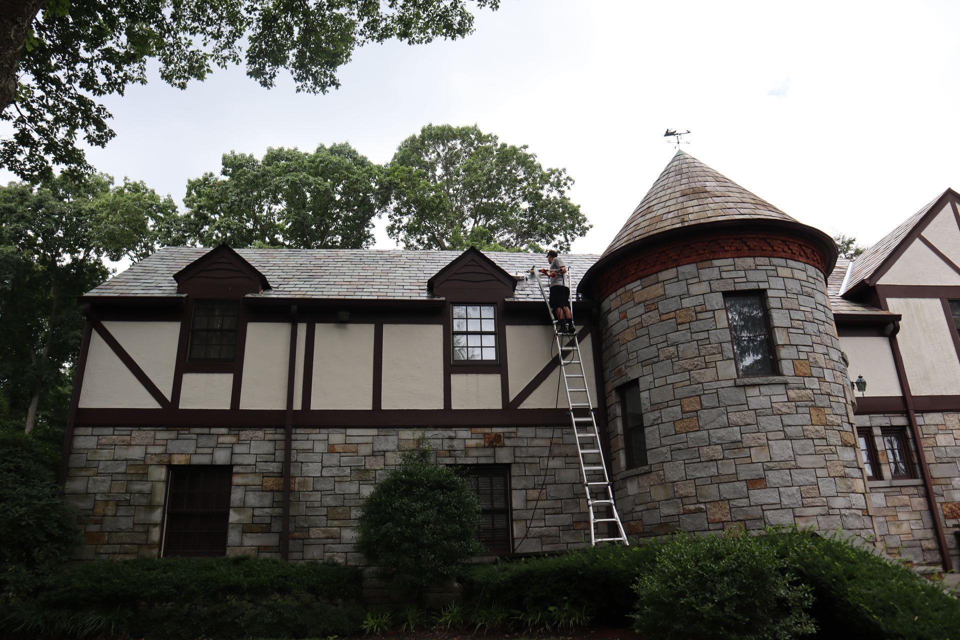 Silvers, Inc. - Pressure washing a wooden surface, revealing clean, light wood from dark, weathered planks.