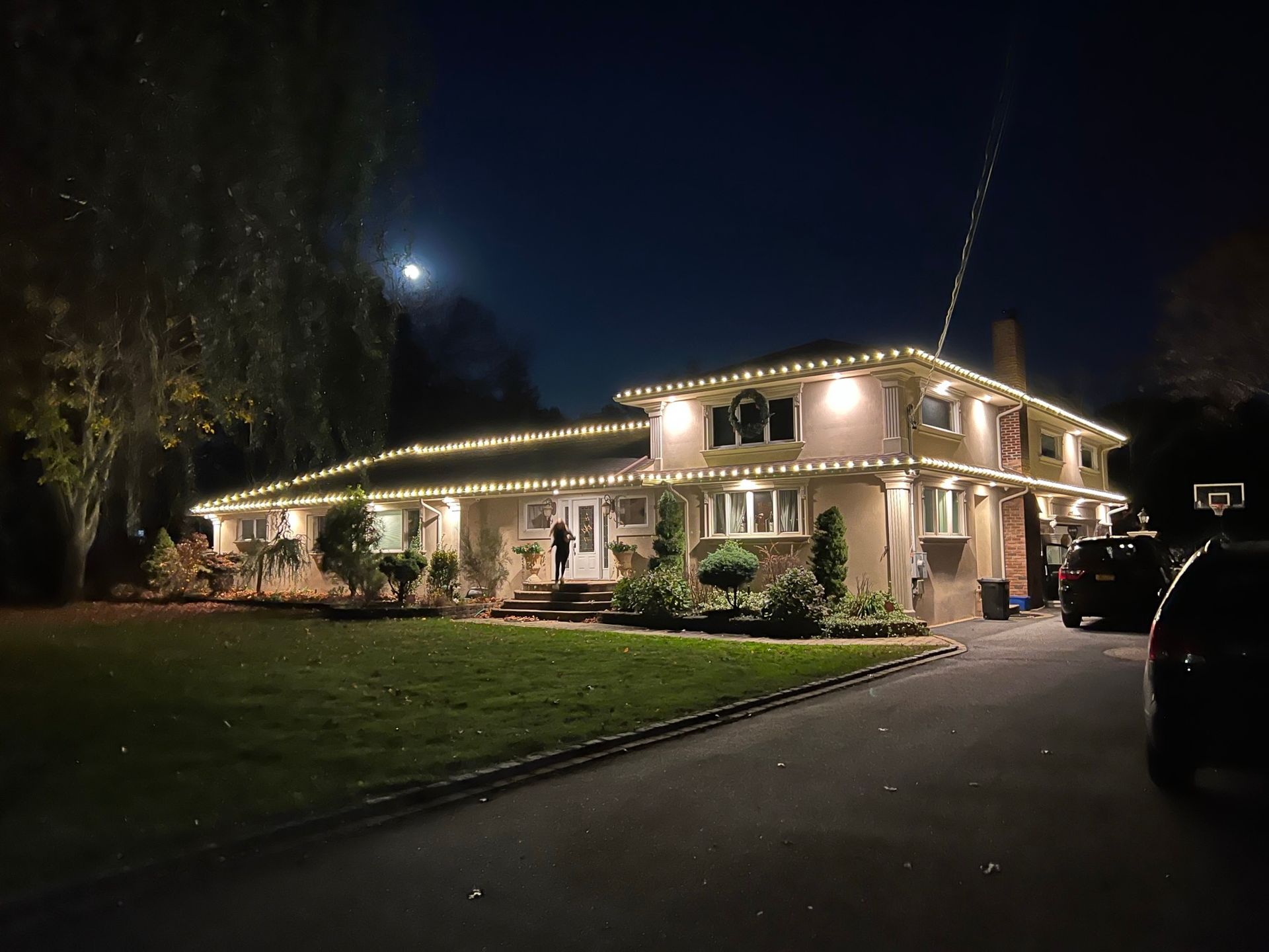 A large house is lit up with christmas lights at night