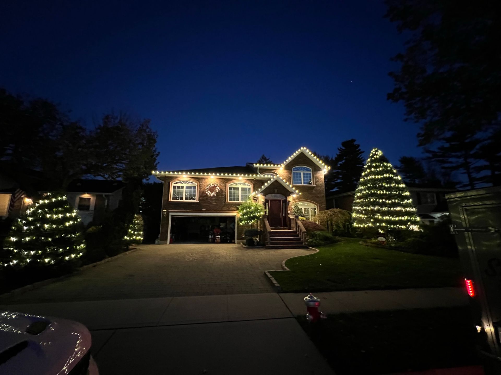 A house with christmas lights on it is lit up at night