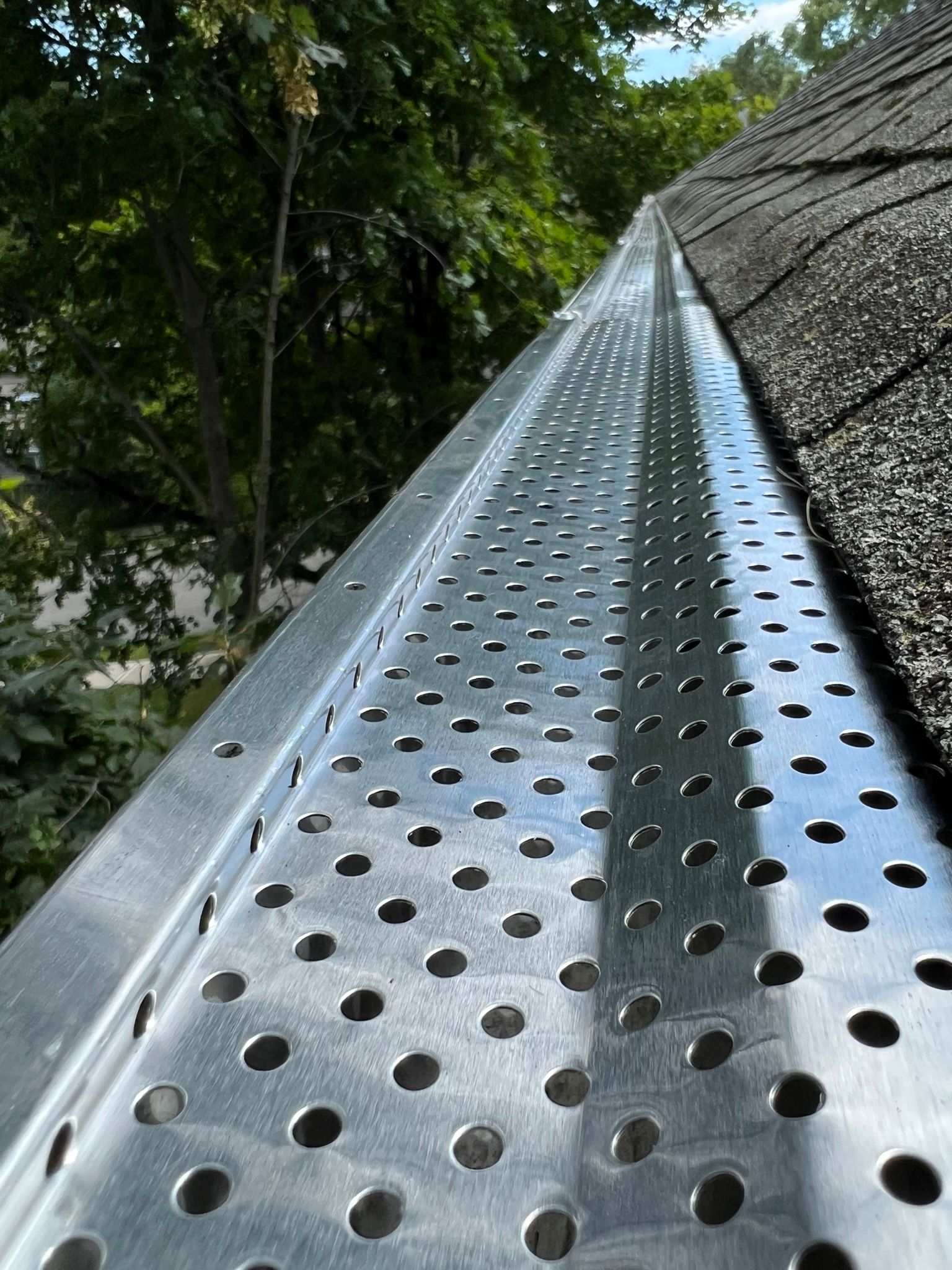 Close-up of metal gutter guard on a residential roofline