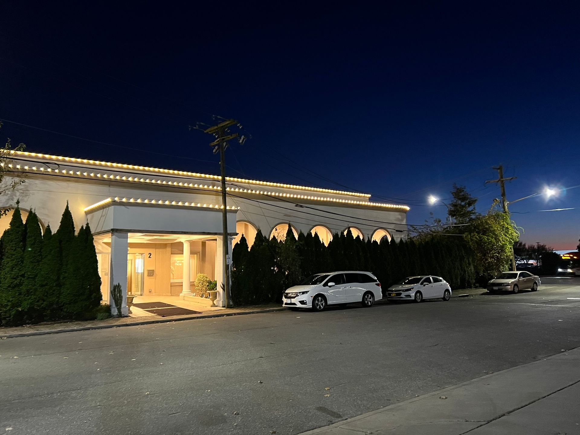 Holiday lights outlining the roof and windows of a house