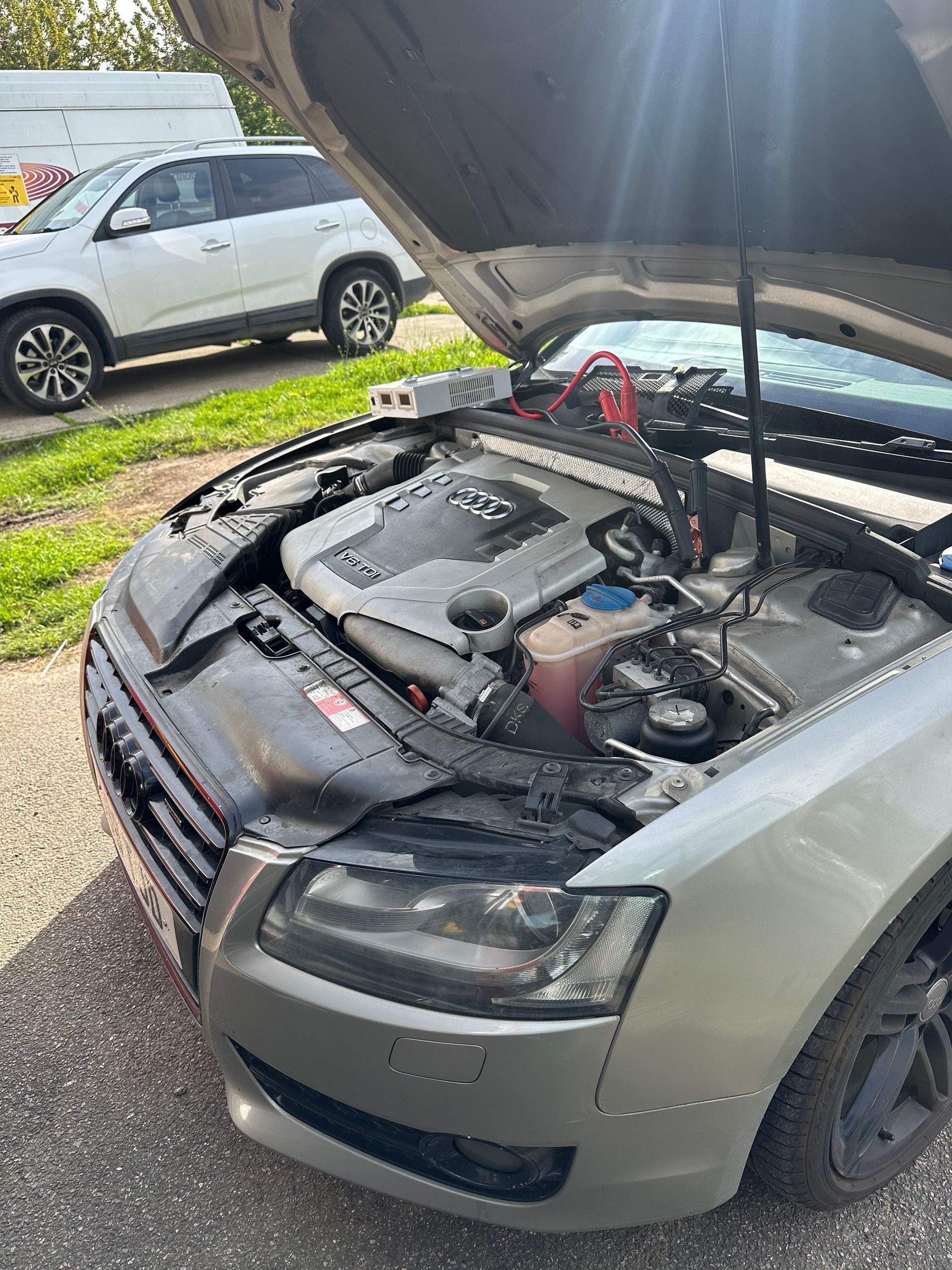 The hood of a car is open and the engine is visible.