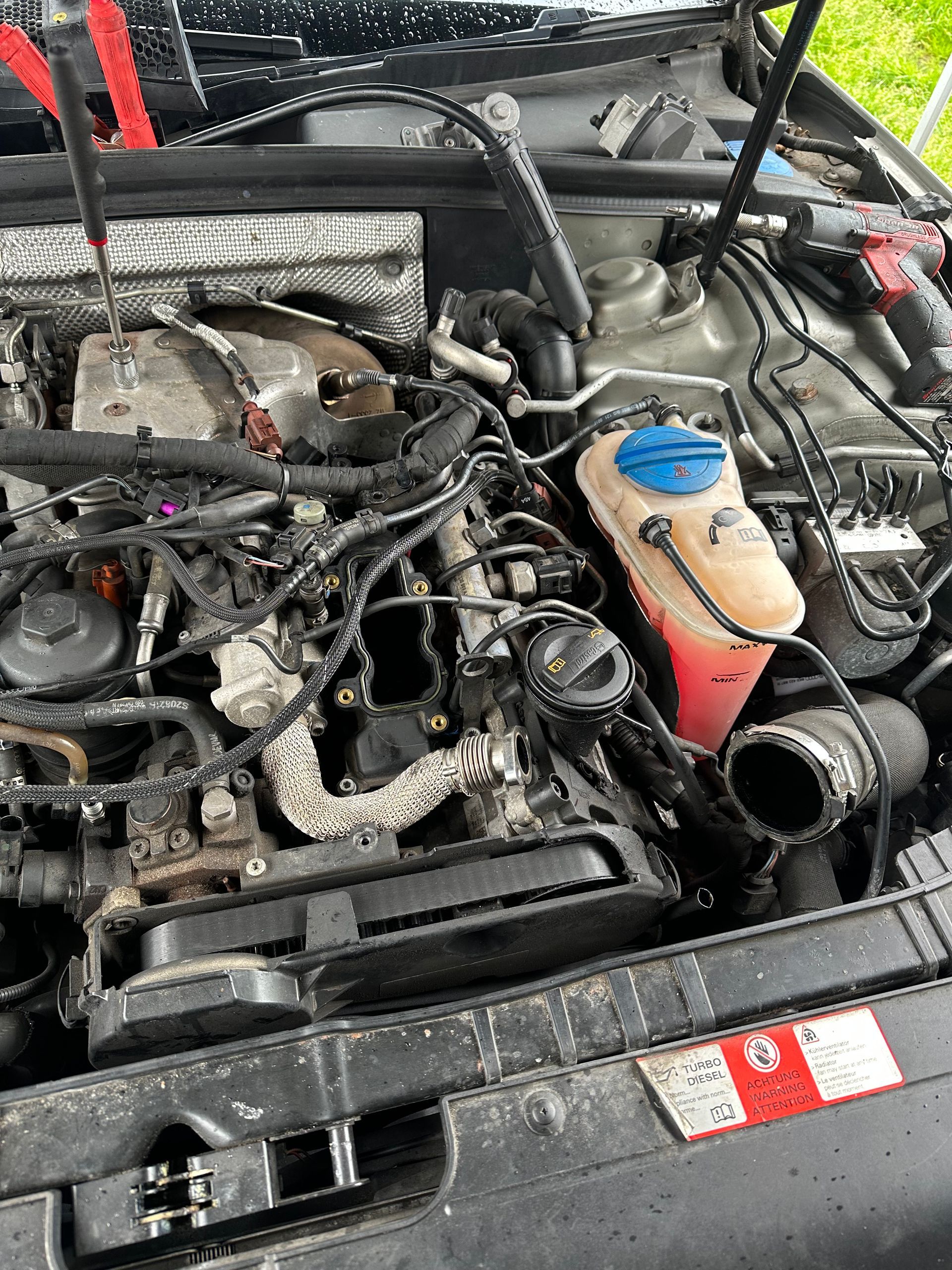 A close up of a car engine with the hood open.
