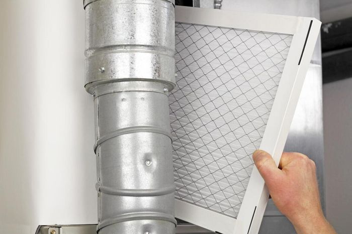 an ac duct cleaning technician replacing an air filter on an air conditioner in surprise