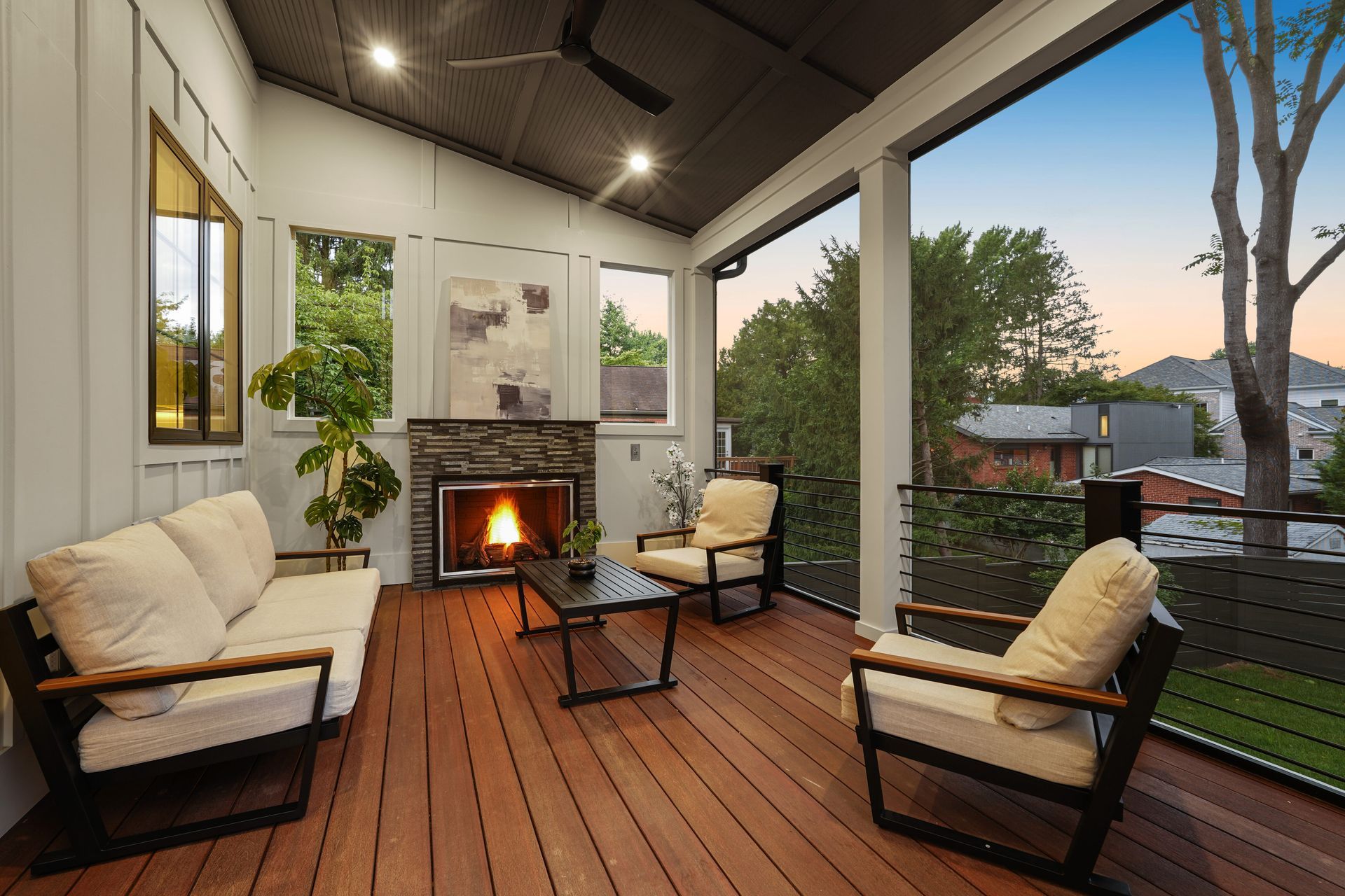 Backyard patio with wicker furniture, large windows, and white house.