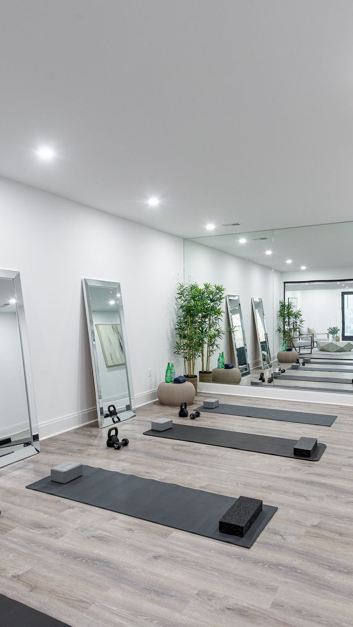 Modern staircase with black steel frame, cable railings, wooden treads. White walls.