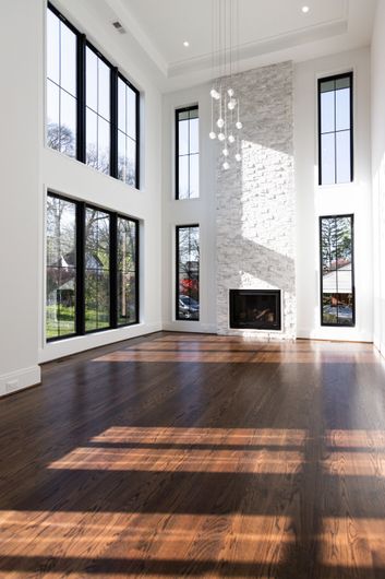 Entryway with wooden doors, staircase, and hardwood floors. Gray walls, white trim, and light fixtures.