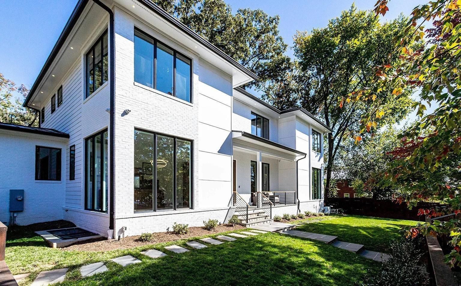 Spacious screened porch with composite deck, black railing, and views of trees and houses.