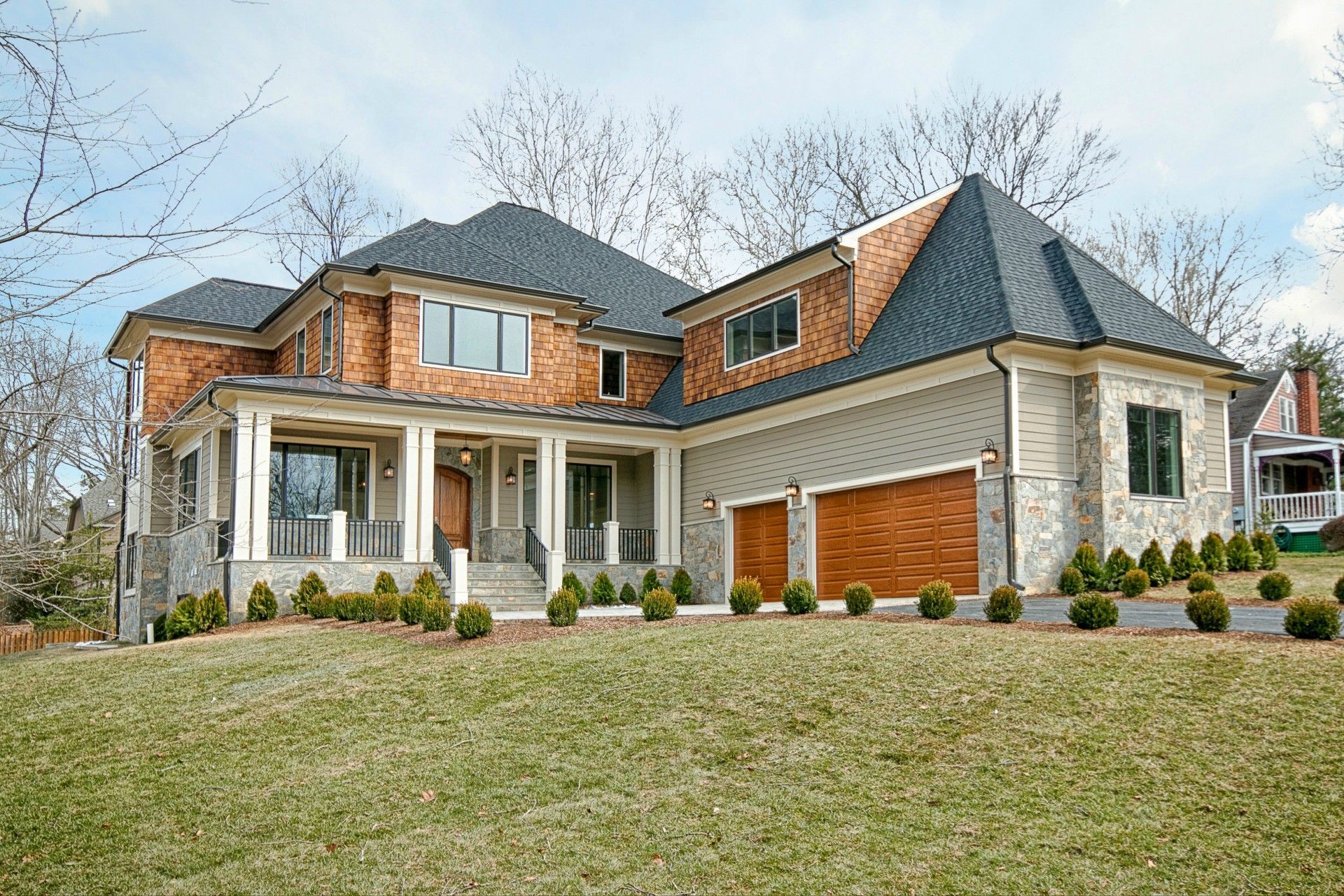 Modern kitchen with white cabinets, stainless steel appliances, and dark island with bar stools.