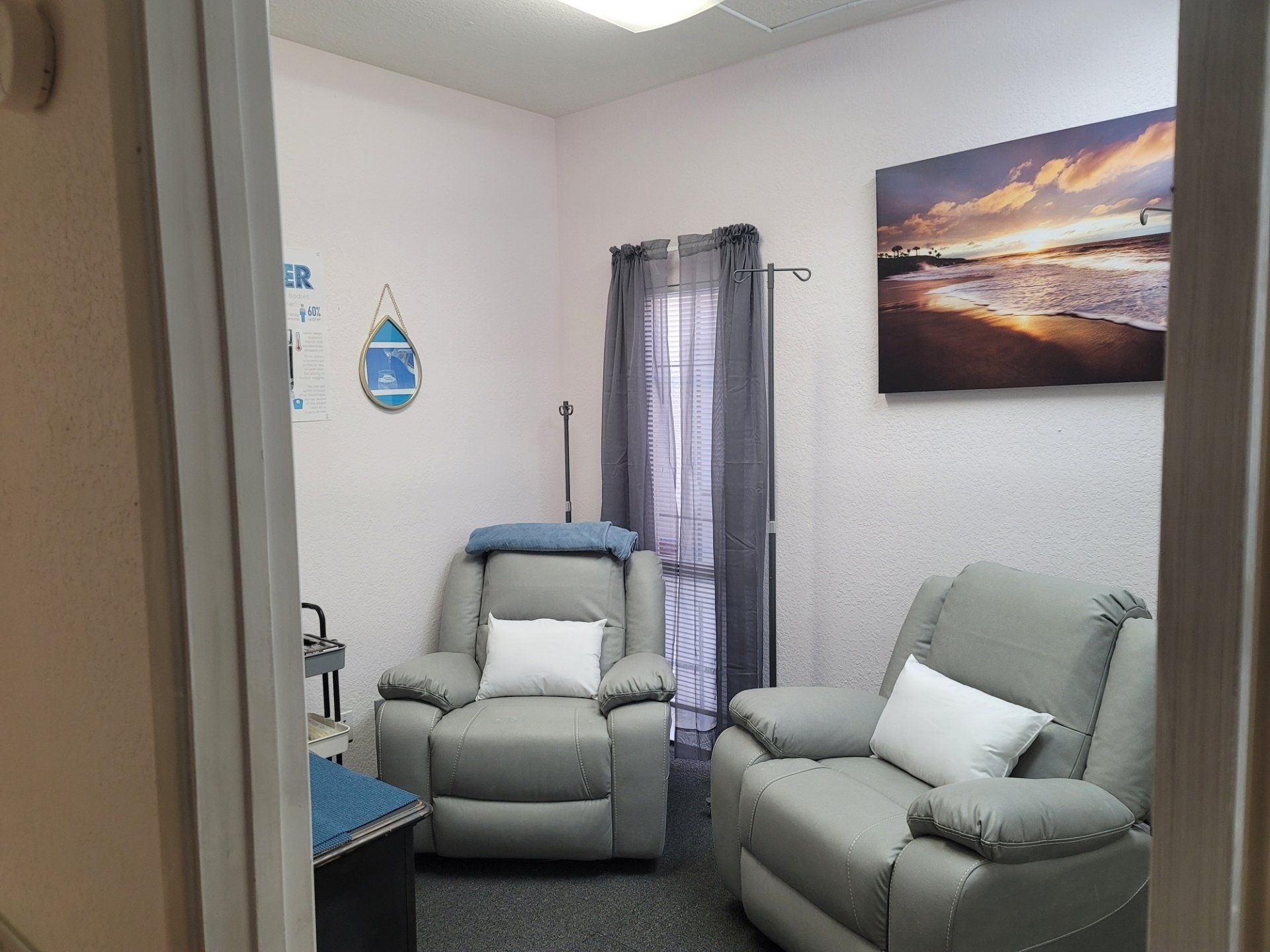 A room with two chairs and a painting on the wall.