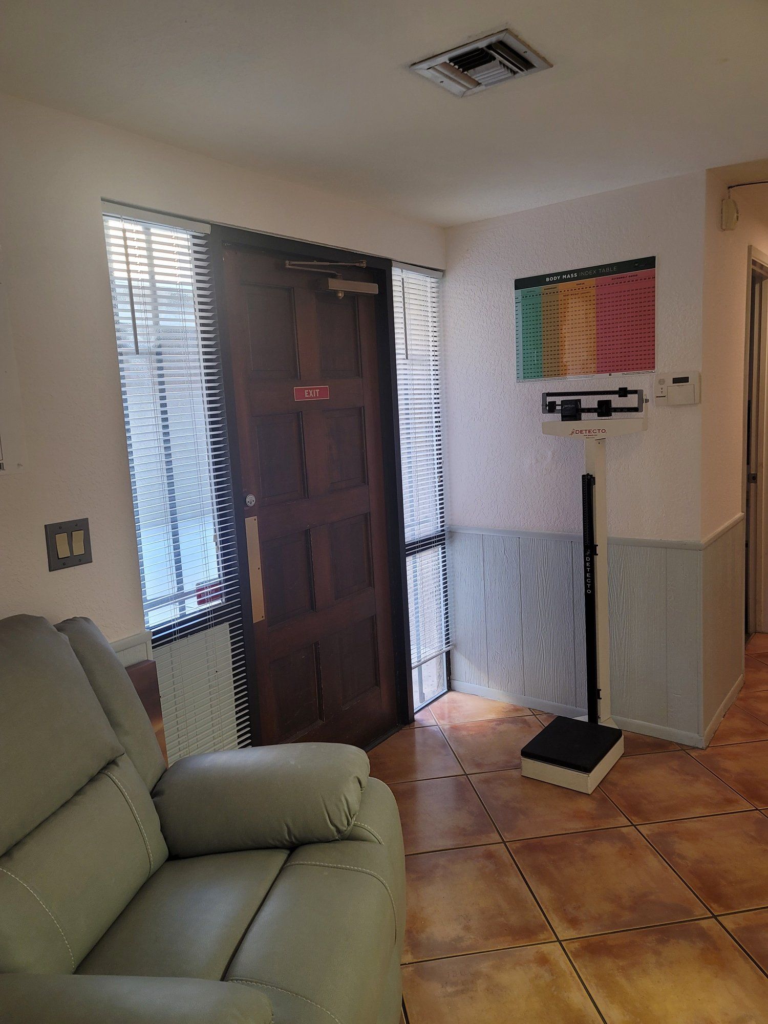 There is a chair and a scale in the room.