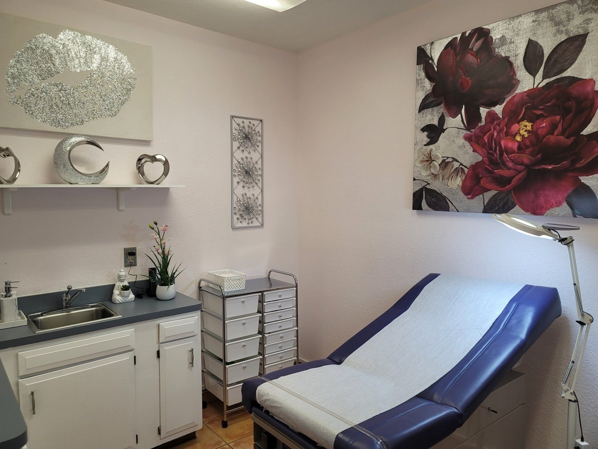 A doctor 's office with a purple exam table and a sink.