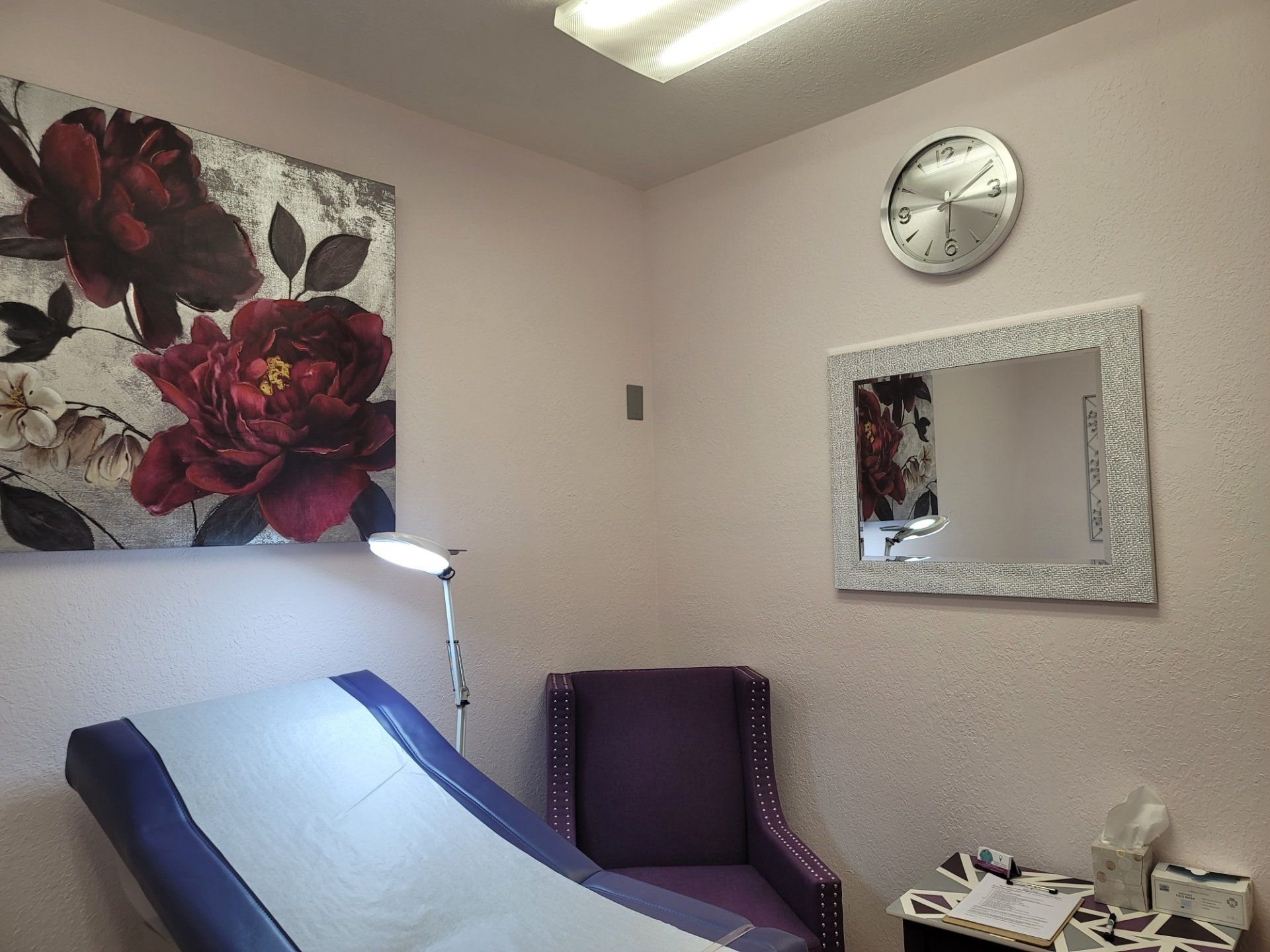 A room with a purple chair and a clock on the wall
