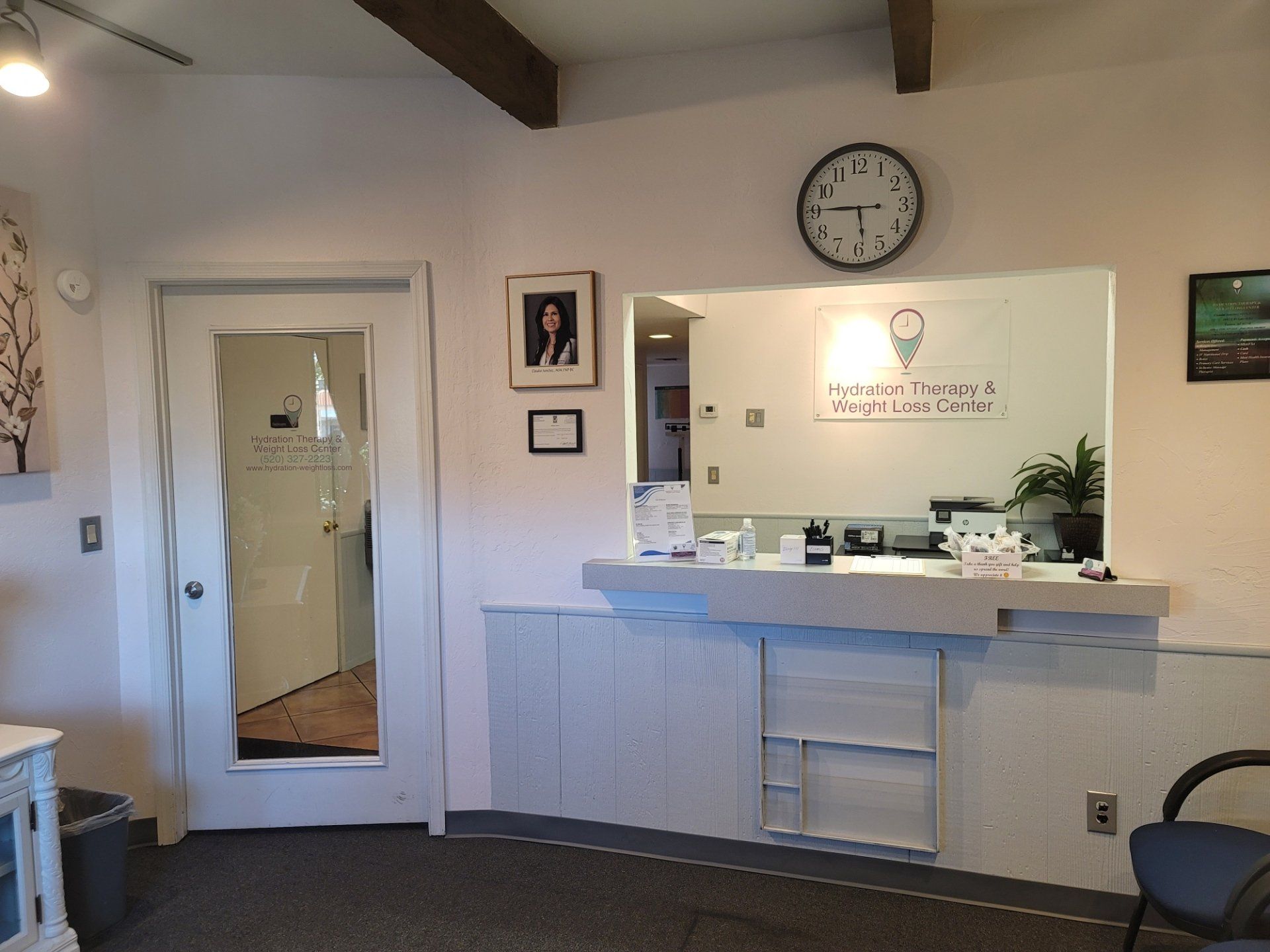 A clock hangs above a counter in a waiting room.
