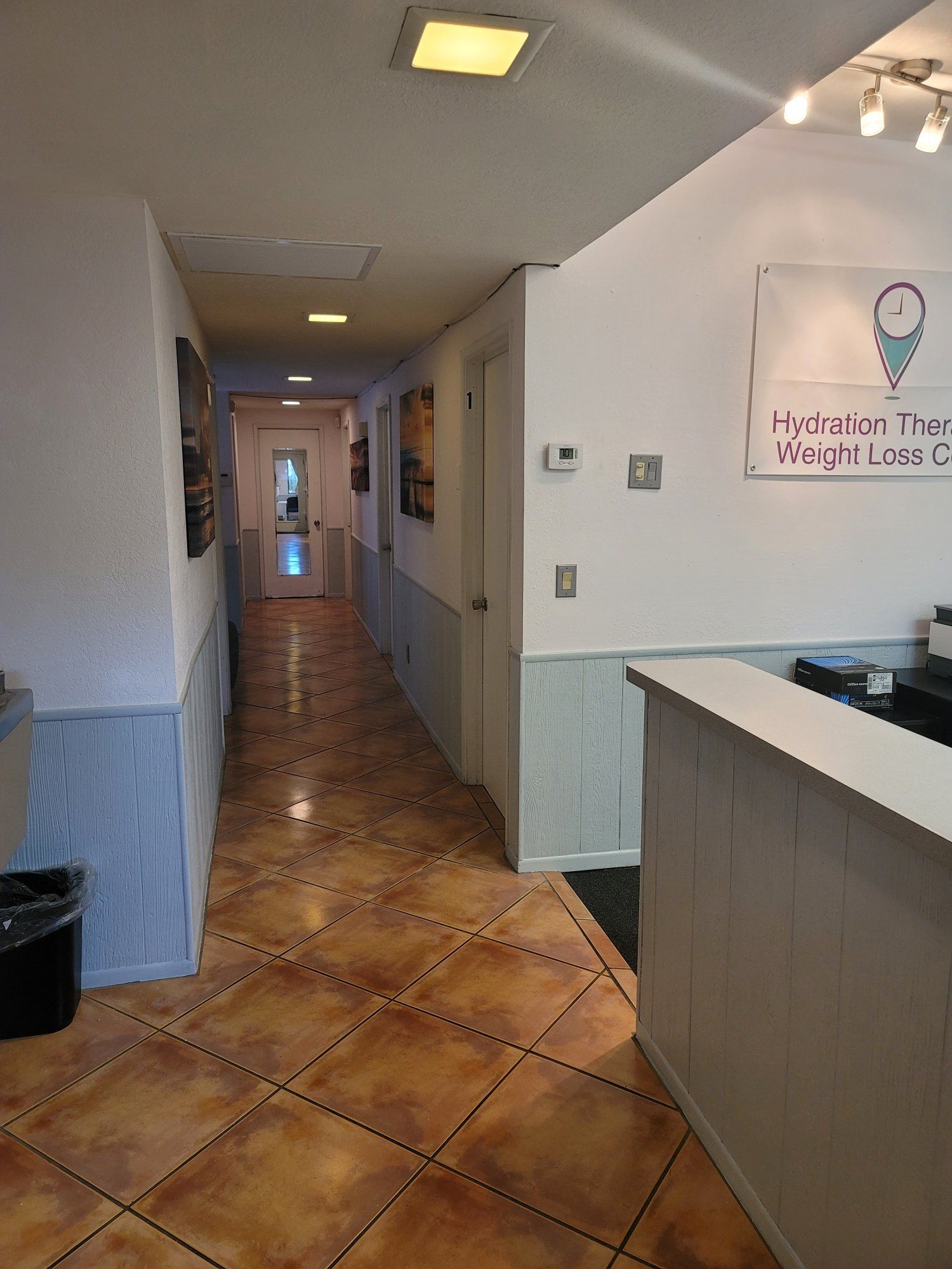 A long hallway leading to a reception desk in a building.