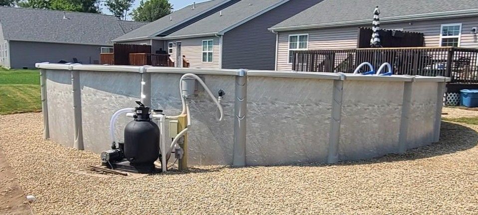 Above ground pool in a backyard, with filtration system.