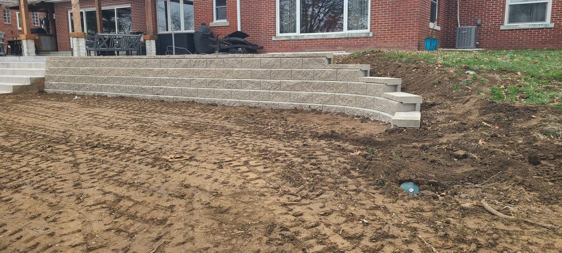 A set of stone steps leading to a house with exposed dirt and construction.
