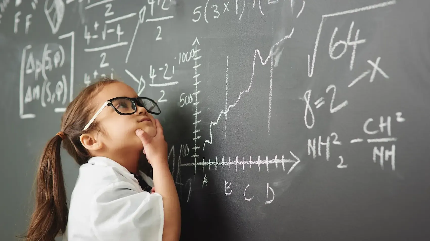 Young person with glasses pondering complex math equations on a chalkboard.