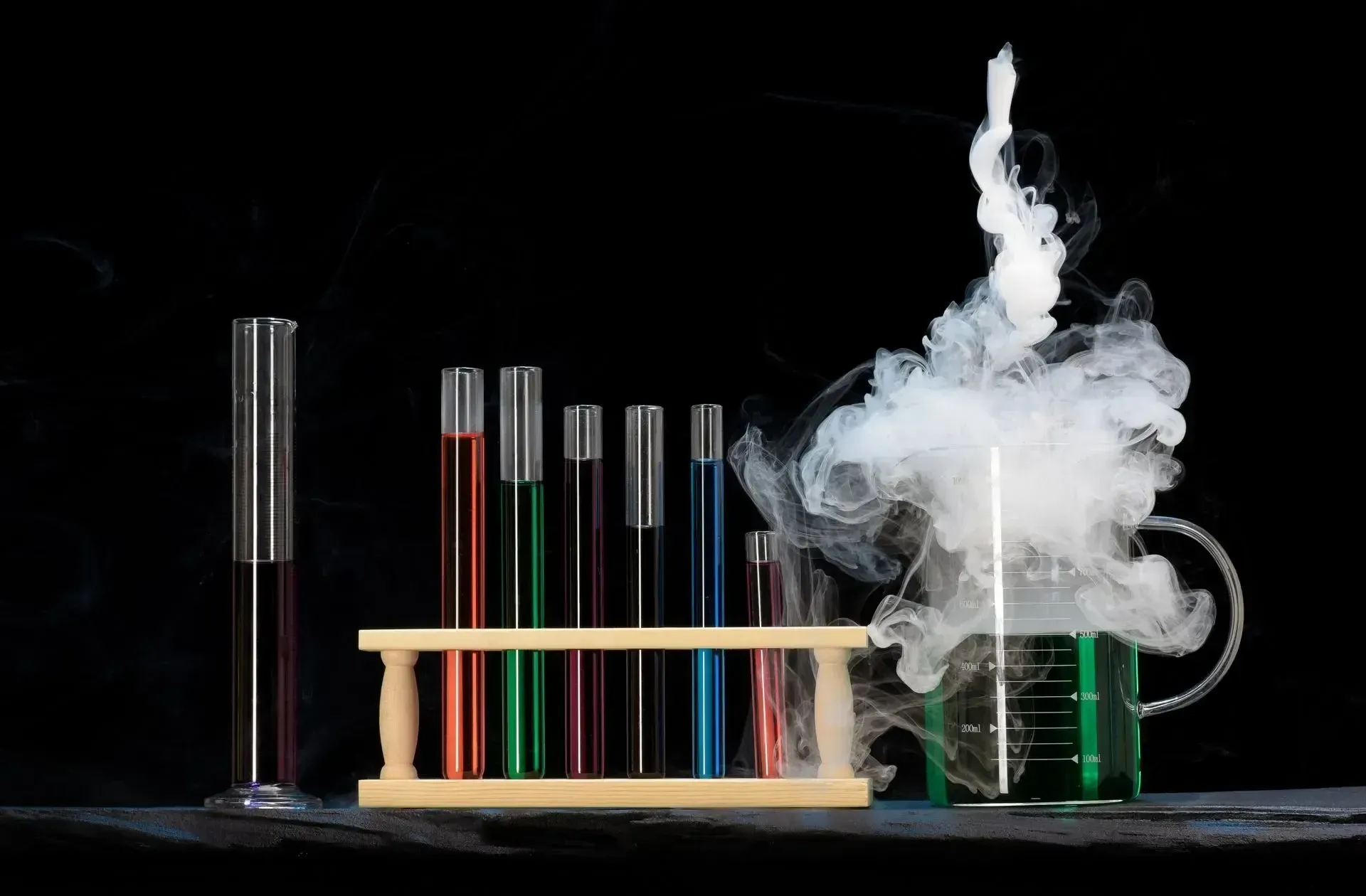 There is smoke coming out of a beaker and test tubes.